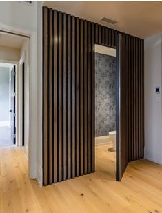 an open door in the middle of a room with wood slats covering it's walls