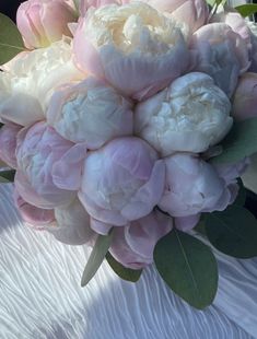 a bouquet of pink and white peonies in the back of a car