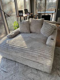 a couch that is sitting in the middle of a room with lots of glass windows