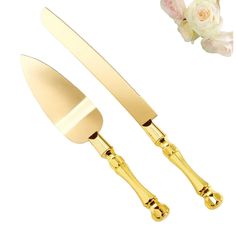 two gold colored utensils with flowers on the side and one has a flower in it