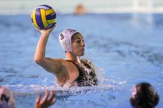 a woman is playing water polo in the pool