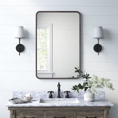 a bathroom vanity with two sinks and a large mirror over the top that hangs on the wall