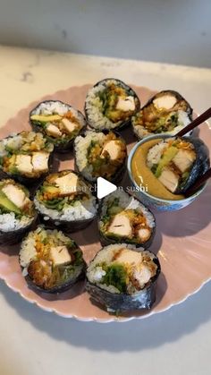 sushi on a pink plate with chopsticks and dipping sauce