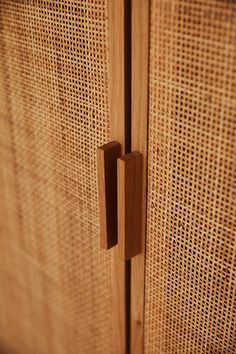 a close up view of a wooden cabinet with woven fabric on the front and sides