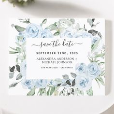 save the date card with blue flowers and greenery