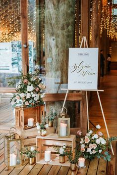 candles and flowers are on display in front of a sign