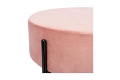 a round pink ottoman with black legs