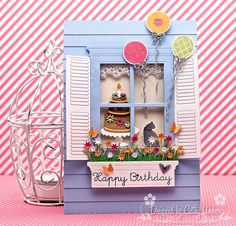 a birthday card with a cake in the window