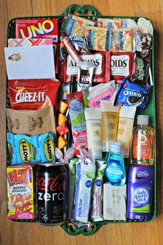 an open suitcase filled with lots of different types of food and drinks on top of a wooden floor