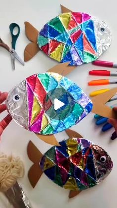 paper plate fish craft with scissors and crayons on the table next to it