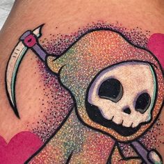 a tattoo with a skull holding a knife and heart shapes on it's thigh