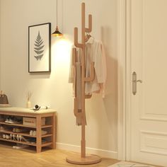 a coat rack in the corner of a room next to a door with shoes on it