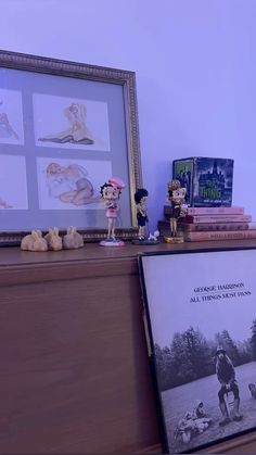 there are many figurines on top of the bookshelf next to each other