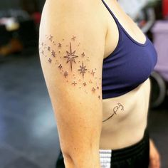 a woman with a star tattoo on her left arm and shoulder, looking at the camera