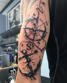 a man's arm with black ink on it and an abstract design in the middle