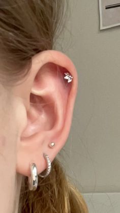 a close up of a person's ear with two piercings on the side