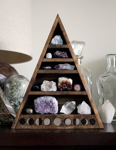 a wooden shelf filled with rocks on top of a table