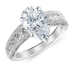 a white gold engagement ring with an oval cut diamond and filigrees on the sides