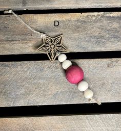 an ornament with beads and a star on it sitting on top of a wooden bench