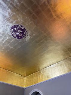 the ceiling in this room is painted gold and silver