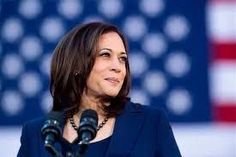 a close up of a person at a podium with an american flag in the background