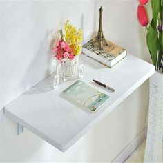 a white table with flowers and books on it