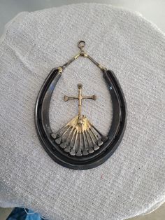 a black and gold necklace with a cross hanging from it's side on top of a table