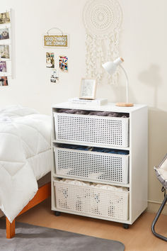 a bedroom with a bed, chair and dresser in the corner next to a white wall