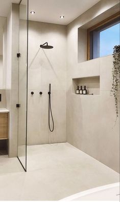 a bathroom with a shower, sink and mirror in it's center wall is shown