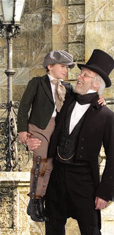 an older man holding a young boy in his arms while wearing a top hat and coat