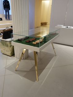 a glass table with some shoes on it and a man standing in the back ground