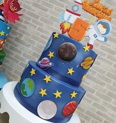 a multi layer cake with space themed decorations on it