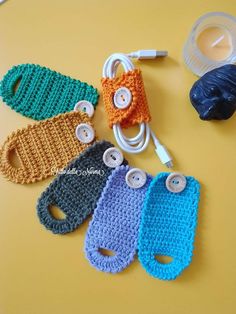 four crocheted cell phones are sitting on a table with ear buds attached to them