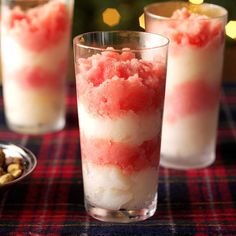 two glasses filled with ice cream sitting on top of a table next to a christmas tree