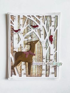 a card with a deer cut out of it's back and trees in the background