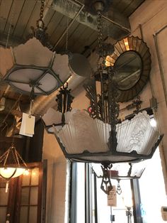 an ornate chandelier hangs from the ceiling in front of a window with mirrors on it