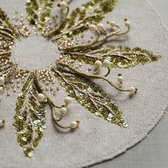 a close up of a piece of cloth with beading on it and flowers in the center