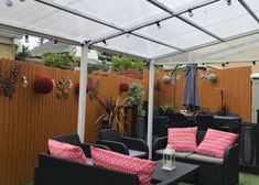 an outdoor living area with couches, tables and umbrellas