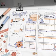 an open planner with coffee and pumpkins on it, next to a laptop computer