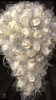 a bridal bouquet with white flowers and pearls