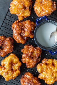 some fried food on a cooling rack next to a bottle of milk and a spoon