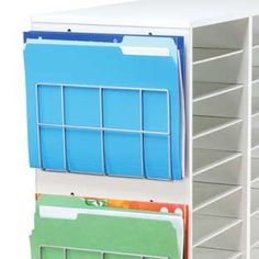 a stack of file folders sitting on top of a white shelf