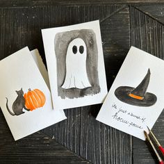 three handmade halloween cards with watercolors on them, one has a ghost and the other has a cat