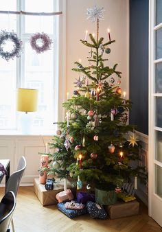 a small christmas tree with presents under it