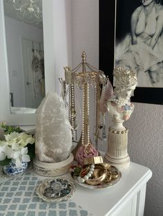 a white table topped with figurines next to a mirror