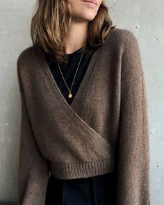 a woman with long hair wearing a brown sweater