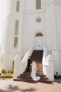 a bride and groom standing on the steps of a church