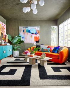 a living room filled with lots of furniture and colorful decor on top of carpeted flooring