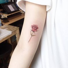 a single rose tattoo on the left arm