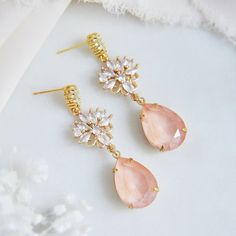 "These whimsical pink drop earrings are the perfect boho bridal earrings for the modern bride. The delicate faceted pink teardrops have a soft glow and are set inside of raw brass which have a warm patina finish enhancing their romantic appeal. The gold plated earring posts are created with sparkling oval cubic zirconia and secured to nature inspired ornate floral cz charms. Whether searching for unique bohemian wedding earrings for your bridesmaids or statement earrings for your next special occasion, all of my jewelry arrives suitably gift wrapped ready for gift giving. Measurements: The whimsical wedding earrings hang approx. 2\" long Metals: Gold plated brass cubic zirconia Gold plated brass posts Gold plated brass butterfly clutches 14k gold filled jump rings raw brass pink teardrop b Bohemian Dangle Crystal Earrings For Wedding, Elegant Pink Teardrop Flower Earrings, Gold Bohemian Crystal Earrings For Wedding, Bohemian Crystal Drop Earrings For Wedding, Bohemian Gold Crystal Wedding Earrings, Pink Teardrop Chandelier Earrings For Gift, Pink Teardrop Jewelry For Wedding, Pink Teardrop Bridal Earrings As Gift, Feminine Dangle Bridal Earrings